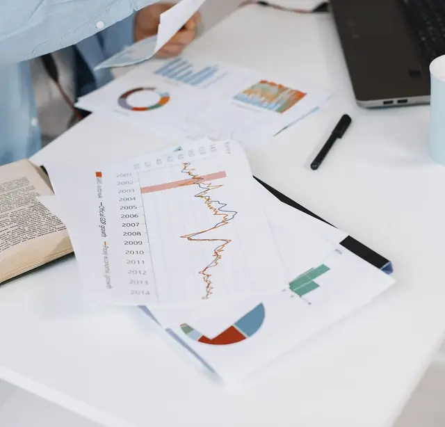 Printed lending reports and charts on a desk during analysis