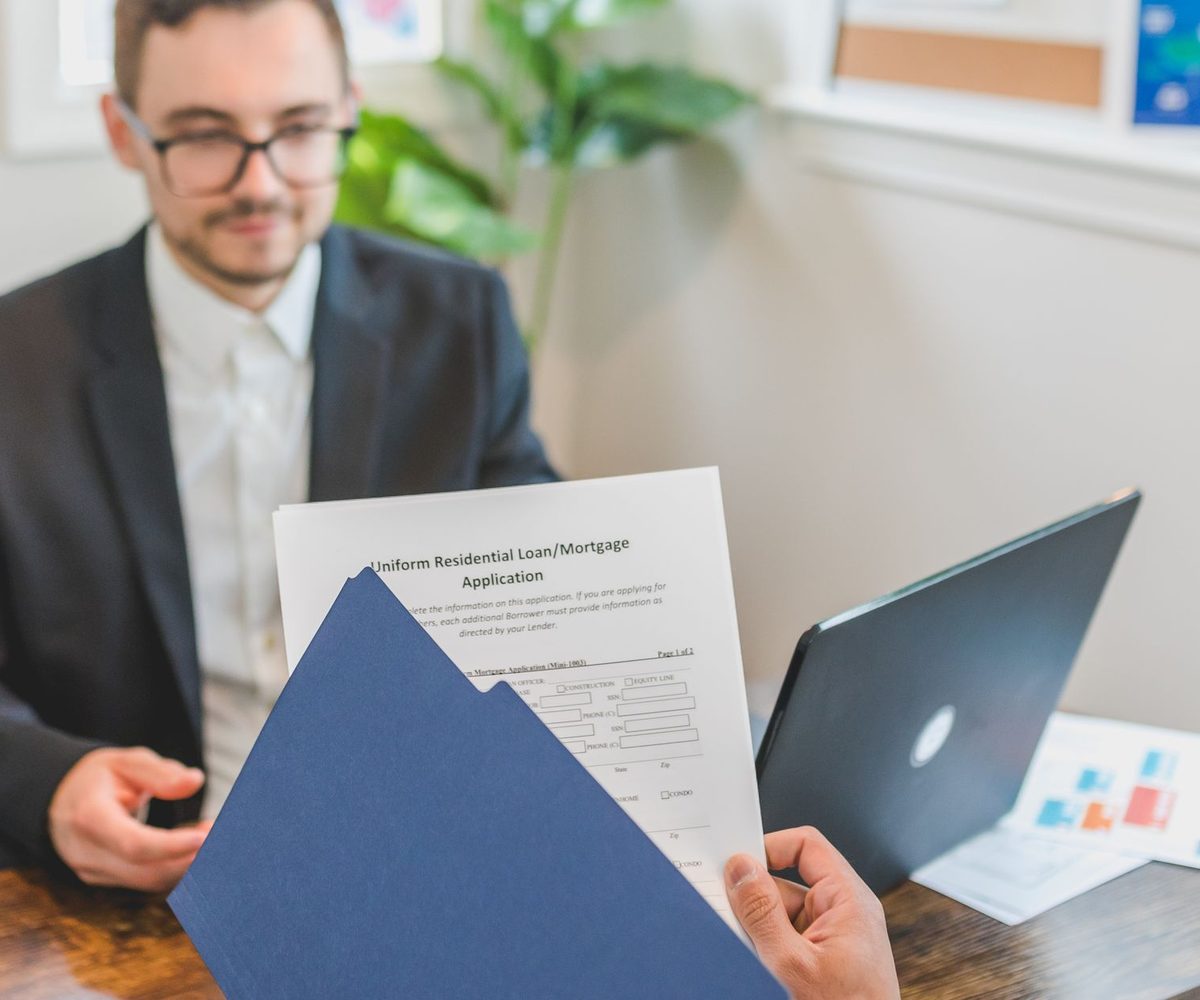 A residential mortgage loan application being handed across a desk, the record fair lending analysis examines