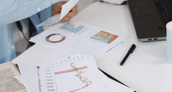 Printed lending reports and charts on a desk during analysis